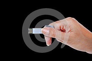 Hand holding Metal Key USB data storage isolated on black background