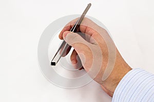 Hand holding a Microchip on tweezers