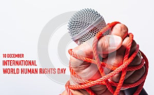 Hand holding microphone and have roped on fist hand with 10 december international HUMAN RIGHTS DAY text