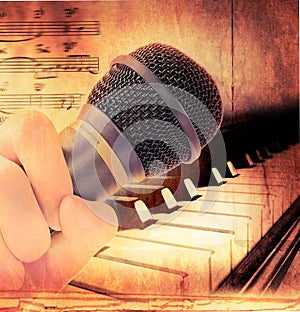 Hand holding microphone and piano