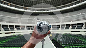 Hand holding a microphone during rehearsal and sound-check before a show at the venue.