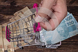 Hand holding mini supermarket cart