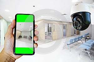 Hand holding  mobile check office or room connect with security camera