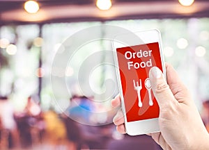 Hand holding mobile with Order food with blur restaurant background, Order food onine business concept
