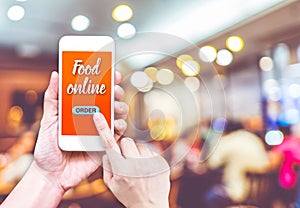 Hand holding mobile with Order food online with blur restaurant