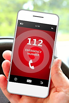 Hand holding mobile phone 112 emergency number