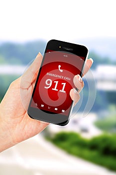 Hand holding mobile phone with emergency number 911