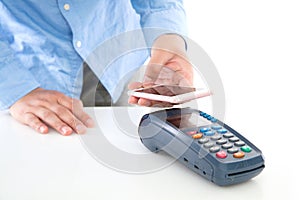 Hand holding mobile phone and scanning payment on pos machine on white background