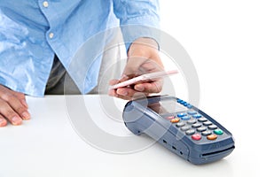 Hand holding mobile phone and scanning payment on pos machine on white background