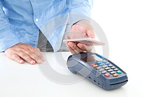 Hand holding mobile phone and scanning payment on pos machine on white background