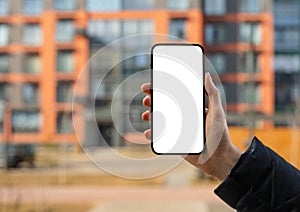 Hand holding mobile phone screen mockup, empty blank smartphone, blurred building