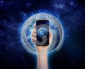 hand holding mobile phone or smart phone on Planet Earth background. Life