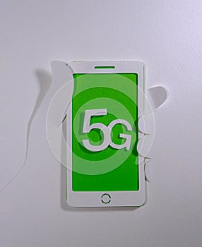 Hand holding mobile phone with technology 5G from paper cut composition