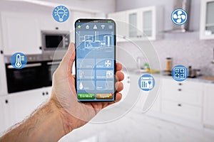 Hand Holding Mobile With Smart Home Control Icon Feature