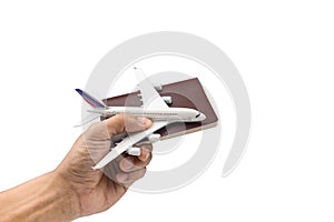 Hand holding a model plane and passport