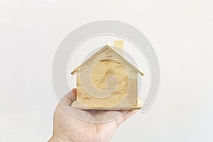 Hand holding model wood house on white background.Thinking and dream