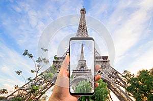 Hand holding the modern smartphone taking a picture of beautiful eiffel tower under blue sky, Eiffel Tower the most romantic