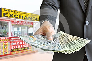 Hand holding money US dollar bills - money exchange concept