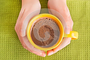 Hand holding a mug with coffee