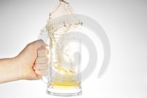 Hand holding mug with splashing beer