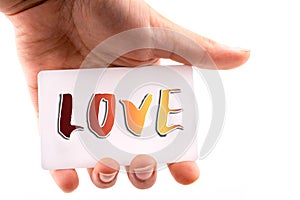 Hand holding a note paper with LOVE wording