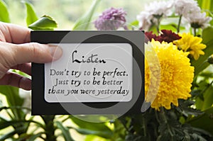 Hand holding notepad with motivational quote - Don& x27;t try to be perfect. Just try to be better than you were