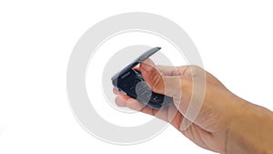 Hand holding obsolete flip cell phone isolated on white background