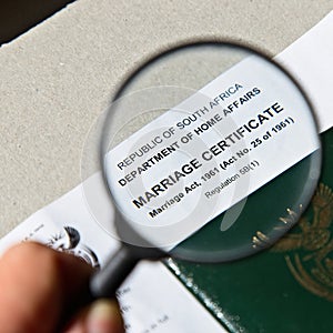 A hand holding an official South African marriage certificate