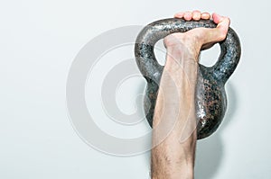 A hand holding old and rusty kettle bell