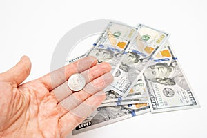 A hand holding one ruble coin and american dollar banknotes on background, ruble devaluation and usd-rub exchange rate concept