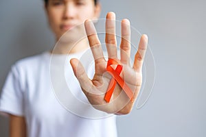 Hand holding Orange Ribbon for Leukemia, Kidney cancer day, world Multiple Sclerosis, CRPS, Self Injury Awareness month.