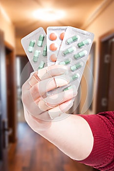 Hand holding packaging of green and orange pills