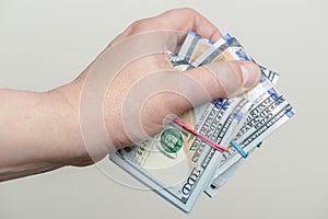 Hand holding packs of hundred dollar banknotes