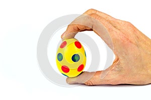 Hand holding painted yellow easter egg with dots