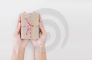 Hand holding parcel post gift box, on white background with copy space