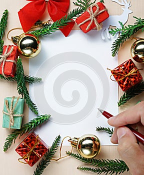 Hand Holding Pen. Blank Paper for Text Surrounded by Christmas Decoration