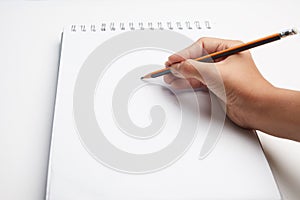 hand holding pen writing on blank white paper. Hand write in the white blank sheet