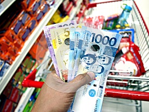 Hand holding Philippine Peso bills