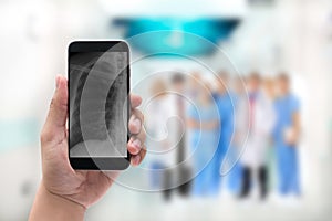 Hand holding a phone with chest x-ray image and Doctor leading a