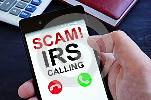 Hand is holding phone with irs scam calls photo