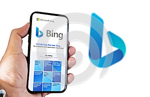 A hand holding a phone with the Microsoft Bing website on the screen