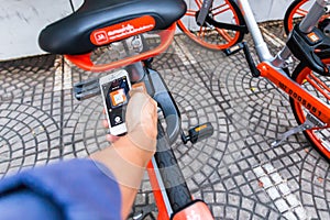 Hand holding phone and scanning qr code, scanning qr code to unlock bike.