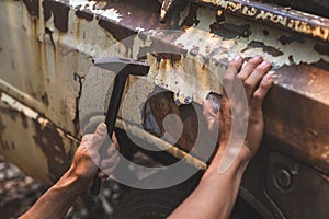 Hand holding a pickup truck hammer rusty peeling paint tires old car wheels vintage