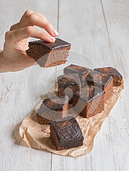 Hand holding a piece of freshly baked brownie