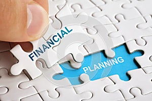 Hand holding piece of puzzle with words Financial Planning.