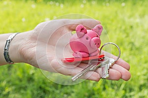 Hand holding piggy and keys as symbol of savings and mortgage