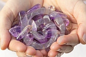 A hand holding a piie of Ametrine photo