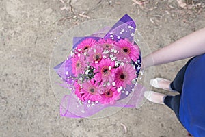 Hand holding pink flowers