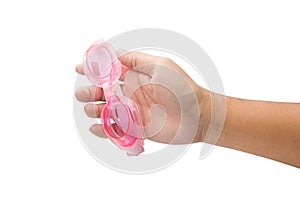 Hand holding pink swim goggles isolated on white background