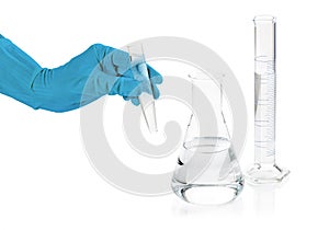 Hand holding a pipette on white background